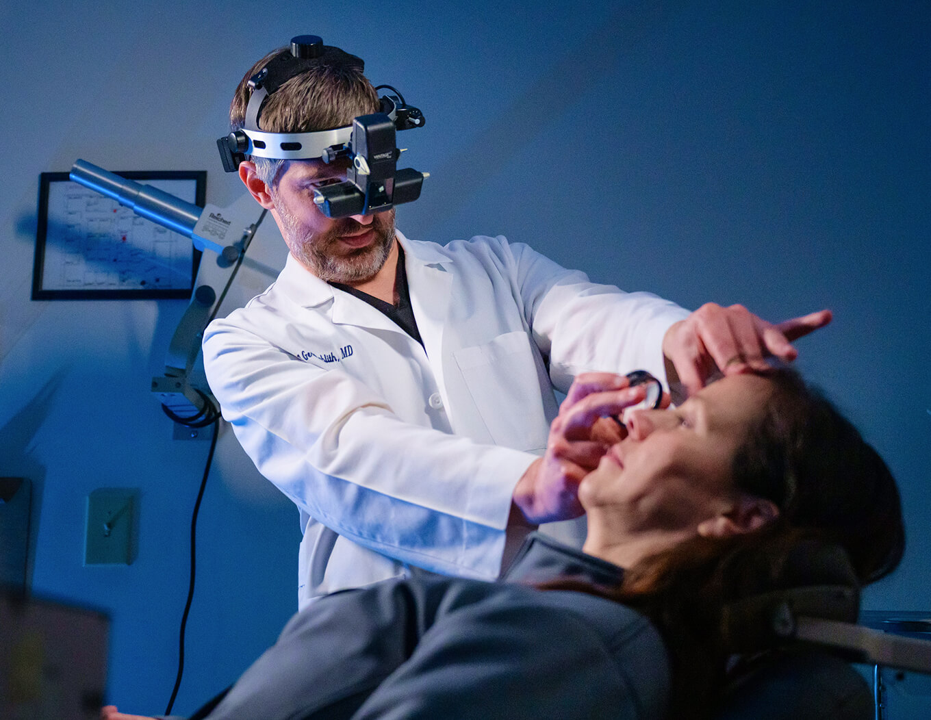 Doctor performing an eye exam on a patient using specialized equipment.
