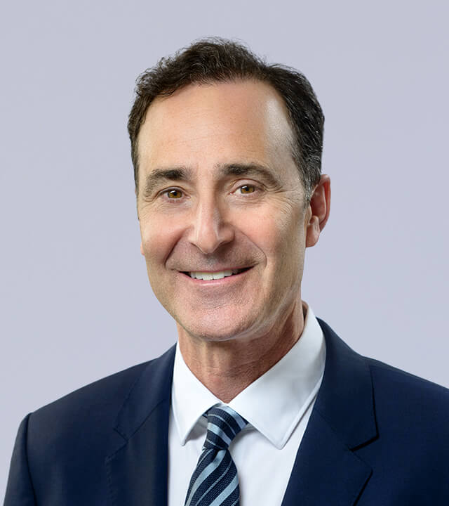 Professional headshot of a smiling man in a suit and tie.